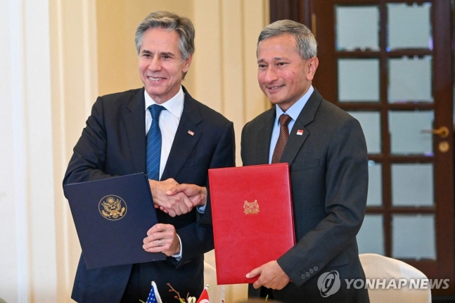 싱가포르 외교장관과 악수하는 블링컨 美 국무장관 (싱가포르 AFP=연합뉴스) 싱가포르를 방문한 토니 블링컨 미국 국무장관(왼쪽)이 31일 싱가포르 외교부에서 비비안 발라크리쉬난 싱가포르 외교장관과 서명식 행사 도중